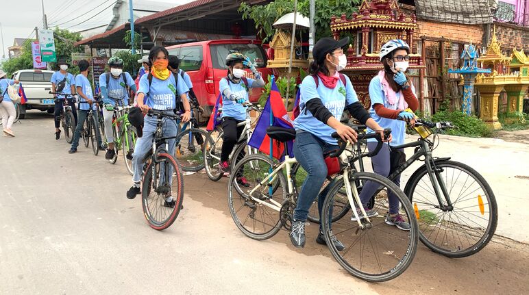 Otto giovani attivisti di Mother Nature manifestano in bicicletta.