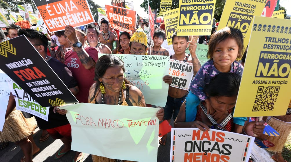 Indigeni protestano con vari cartelli