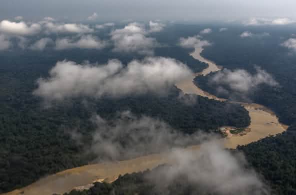 Veduta aerea con nuvole di un fiume che serpeggia nella foresta pluviale
