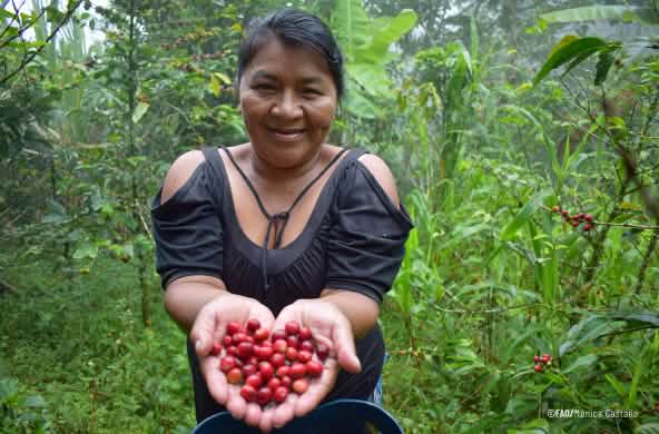 Una donna indigena nella foresta mostra dei frutti rossi