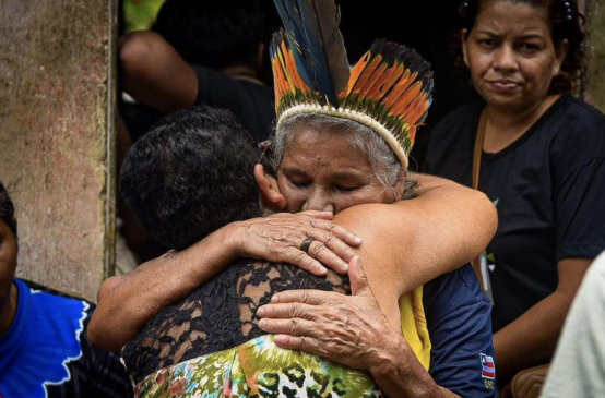 María Muñiz Tupinambá, sorella della leader indigena assassinata María de Fátima Muñiz Pataxó "Nega", viene abbracciata da un partecipante alle esequie.