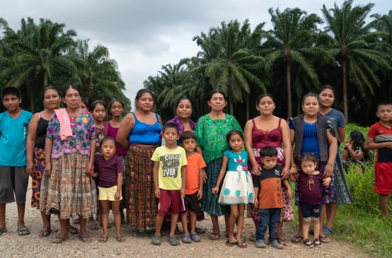 Gruppo di donne e bambini della comunità guatemalteca Chapín Abajo, messa all'angolo dalle piantagioni di palma africana.