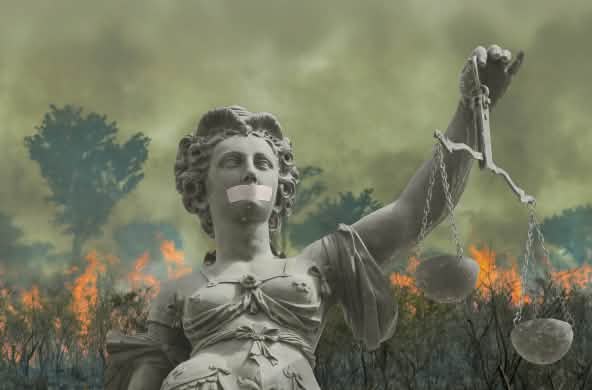 Fotomontaggio: Justitia davanti alla foresta tropicale in fiamme