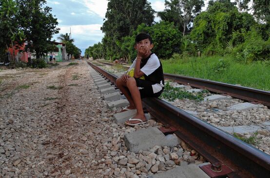 Un bambino seduto sul vecchio binario che si trova sul percorso previsto per il progetto del Treno Maya, in Messico.