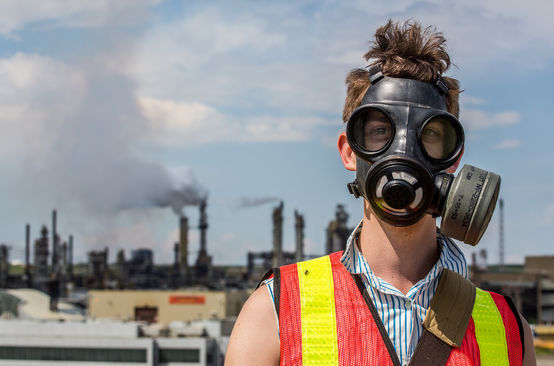 Un uomo protesta con una maschera antigas contro l'estrazione delle sabbie bituminose in Canada.