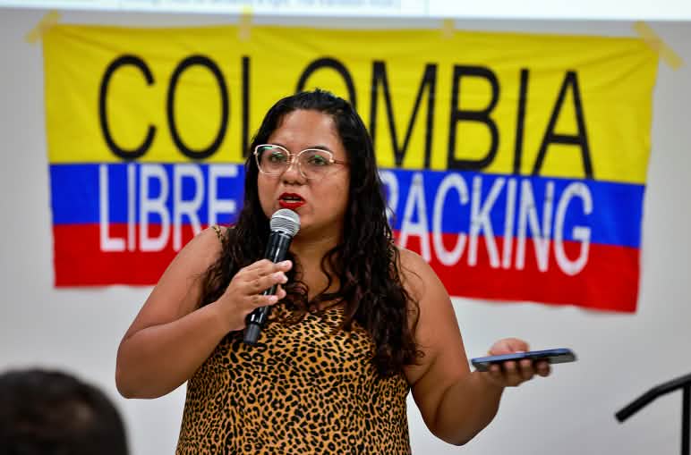 Partecipante al Vertice dei Popoli Oltre i Combustibili Fossili, con alle spalle un cartello recante la scritta “Colombia libera dal fracking”
