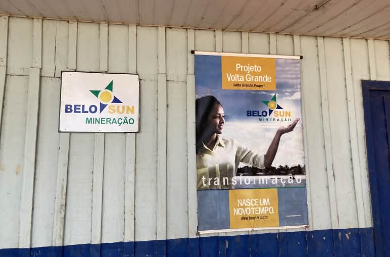 Un'insegna della società mineraria Belo Sun e un cartellone pubblicitario dell'azienda sulla parete di una capanna di legno.