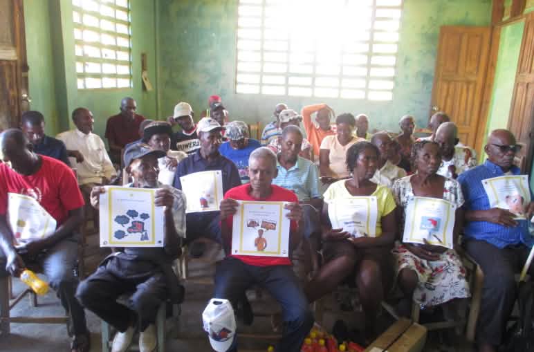 Gruppo comunitario del nord-est di Haiti con le carte del gioco delle 50 domande sull'estrazione mineraria