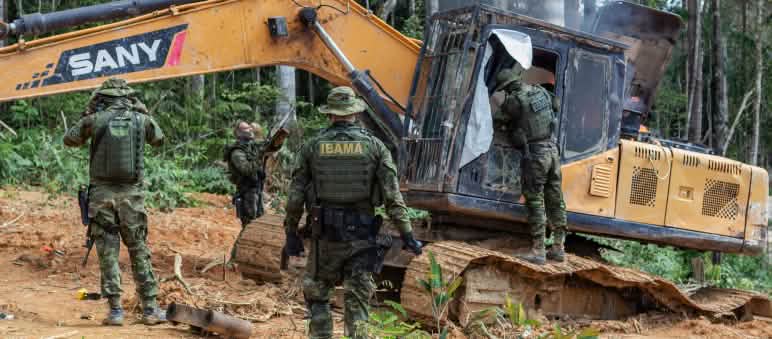 Intervento dell'agenzia ambientale IBAMA. Un gruppo di uomini in tenuta militare interviene su una draga gialla nella foresta pluviale.