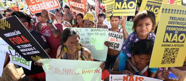 Indigeni protestano con vari cartelli
