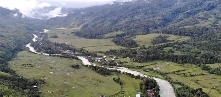 Foto aerea di una valle con un fiume e piccoli villaggi.