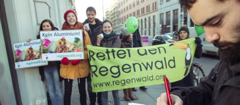Difendere chi difende, porre fine alle cause intimidatorie Attivisti di Salviamo la Foresta/Rettet den Regenwald manifestano con alcuni striscioni
