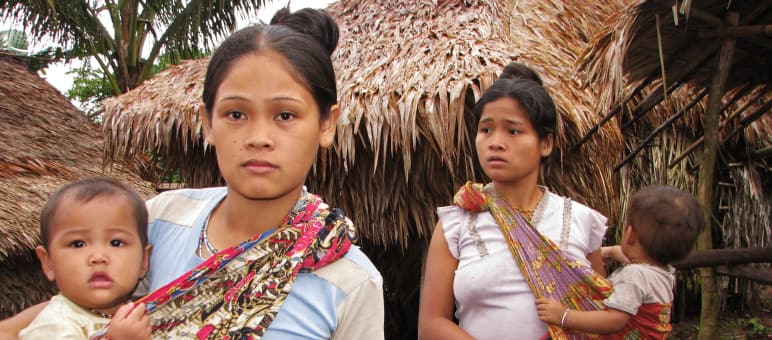Le comunità indigene di Palawan, native dell'isola, hanno bisogno della loro foresta - non di piantagioni - per vivere. Due donne con i loro figli accanto alle case tradizionali di paglia