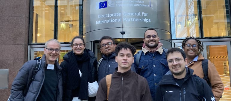 Foto di gruppo di 7 persone davanti all'ingresso di un edificio della Commissione europea a Bruxelles.