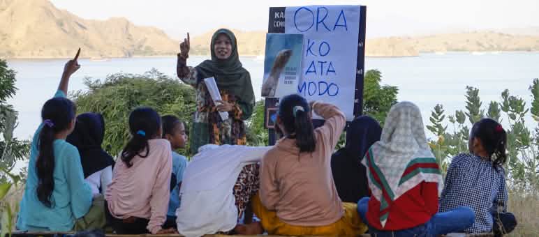 Le ragazze imparano a conoscere il drago di Komodo attraverso le fotografie