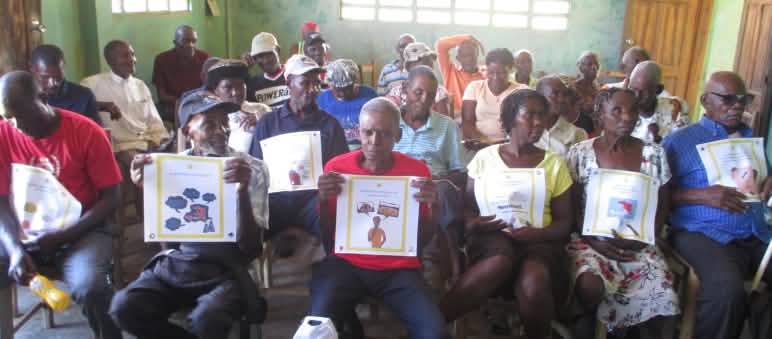 Gruppo comunitario del nord-est di Haiti con le carte del gioco delle 50 domande sull'estrazione mineraria