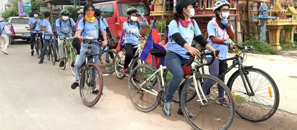 Otto giovani attivisti di Mother Nature manifestano in bicicletta.
