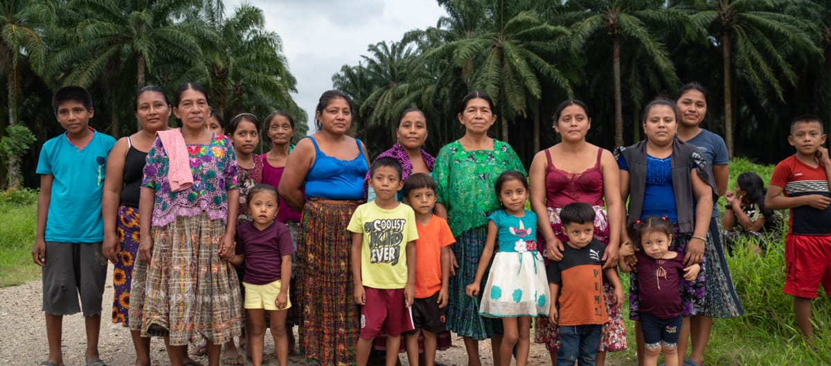 Gruppo di donne e bambini della comunità guatemalteca Chapín Abajo, messa all'angolo dalle piantagioni di palma africana.