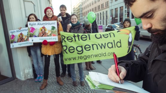 Attivisti di Salviamo la Foresta/Rettet den Regenwald manifestano con alcuni striscioni