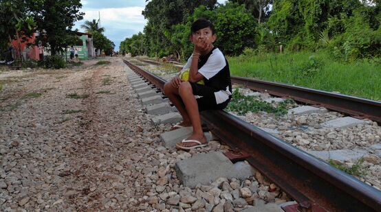 Un bambino seduto sul vecchio binario che si trova sul percorso previsto per il progetto del Treno Maya, in Messico.