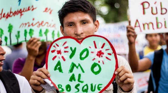 Dimostrante con un cartello "Amo la foresta" a Iquitos, Perù.