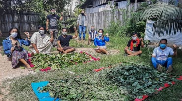 Gruppo di indigeni mentre preparano piante per uso medicinale