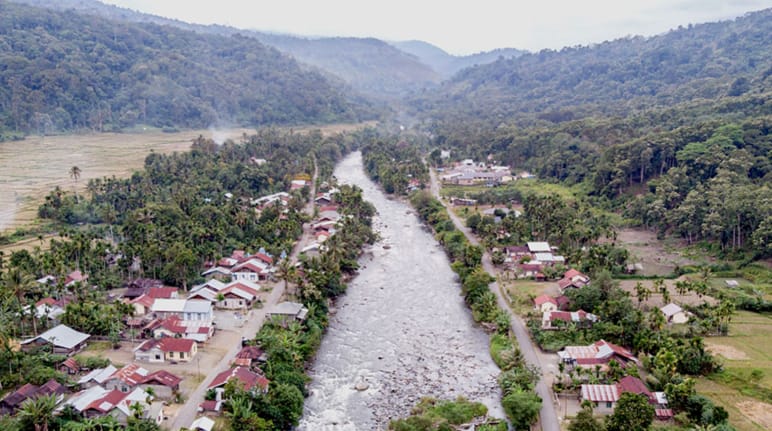 Il fiume attraversa il villaggio, sullo sfondo le montagne
