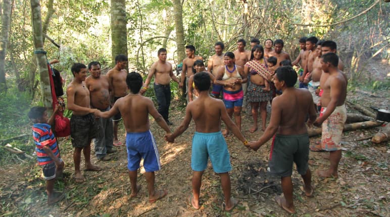 Gli indigeni Ka'apor - bambini, donne e uomini - uniscono le loro mani e formano un cerchio nella foresta tropicale.