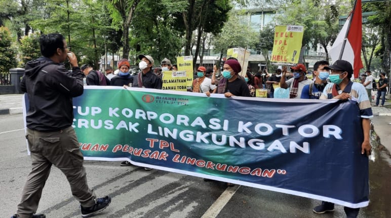 Fotografo e manifestanti con striscione verde