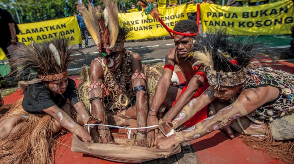 Quattro papuani con gioielli di piume eseguono un rituale. "Papua non è una terra vuota