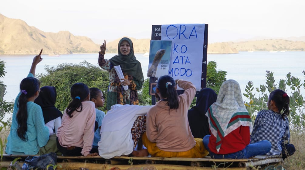 Le ragazze imparano a conoscere il drago di Komodo attraverso le fotografie