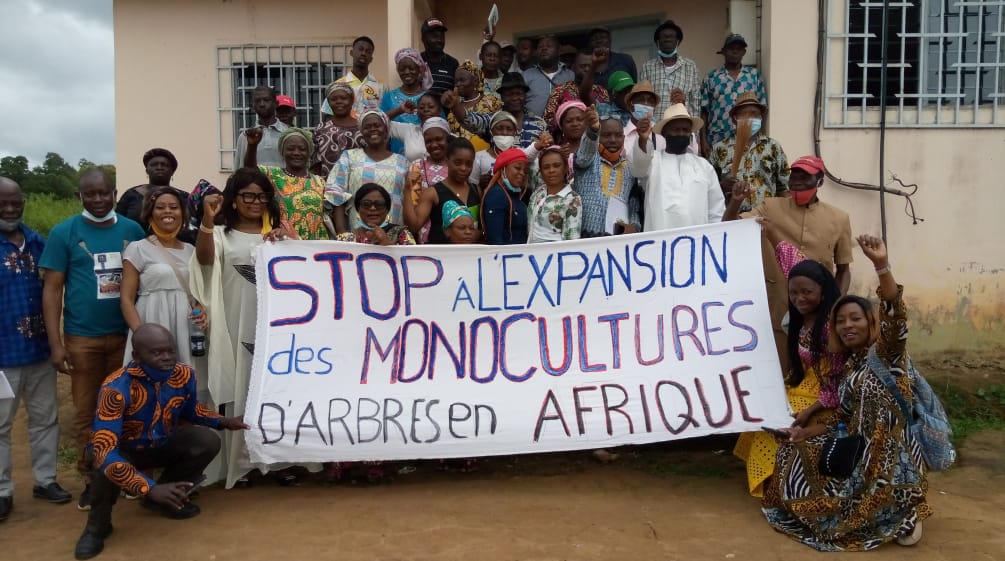 Un gruppo di persone colpite protesta con uno striscione che recita (in francese): "Stop all'espansione delle piantagioni di alberi da monocoltura in Africa".
